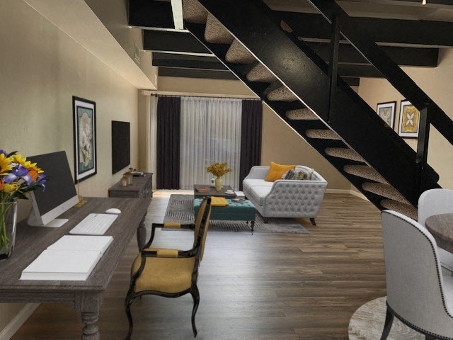 a living room with a desk and a staircase