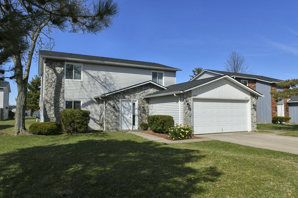 a white house with a white garage door and a lawn