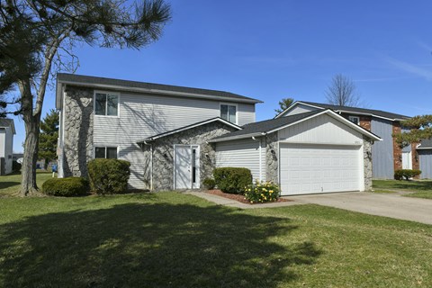 a white house with a white garage door and a lawn