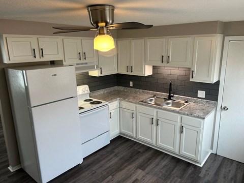 a kitchen with white cabinets and a white refrigerator