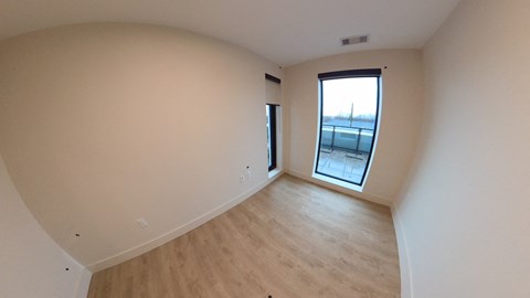 A room with a window and wooden flooring.