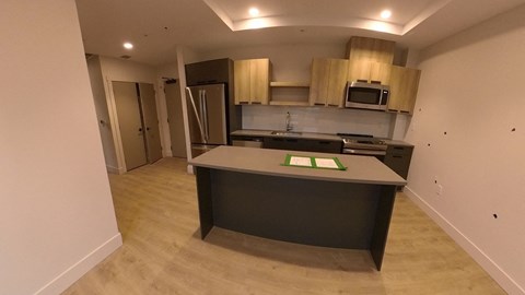 A kitchen with a refrigerator, microwave, and oven.