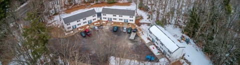 Winter aerial view of Hilltop apartments at 840 Hollis Road, two-story townhouse-style buildings around a central parking lot