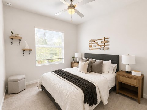 A bedroom with a large bed and a ceiling fan.