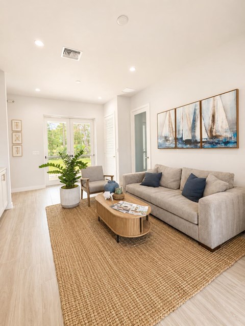 A living room with a couch, a chair, a coffee table, and a painting on the wall.