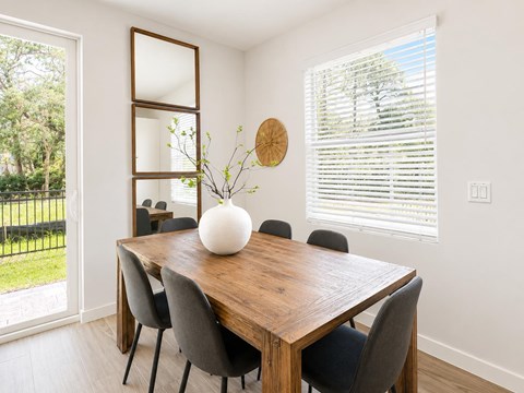 A dining room with a wooden table and chairs.