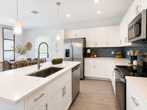 A modern kitchen with white cabinets and a black countertop.
