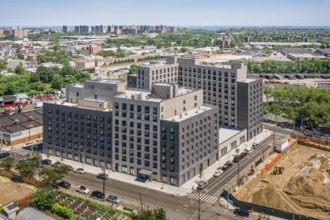 A large grey building with many windows is under construction.