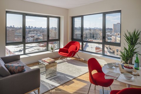 A living room with a view of the cityscape through large windows.