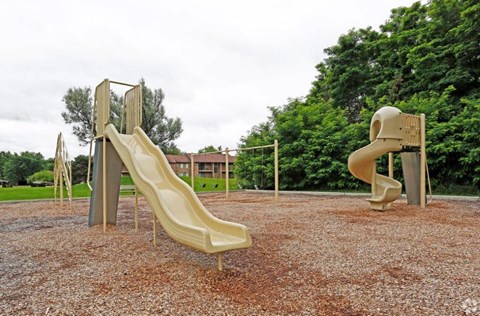 two slides on a playground in a park