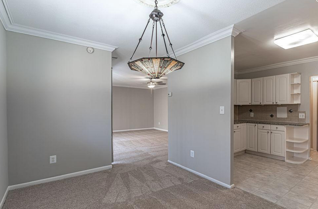 an empty kitchen and living room with a chandelier