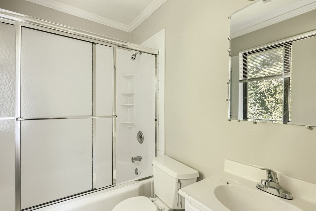 a white bathroom with a shower and a sink