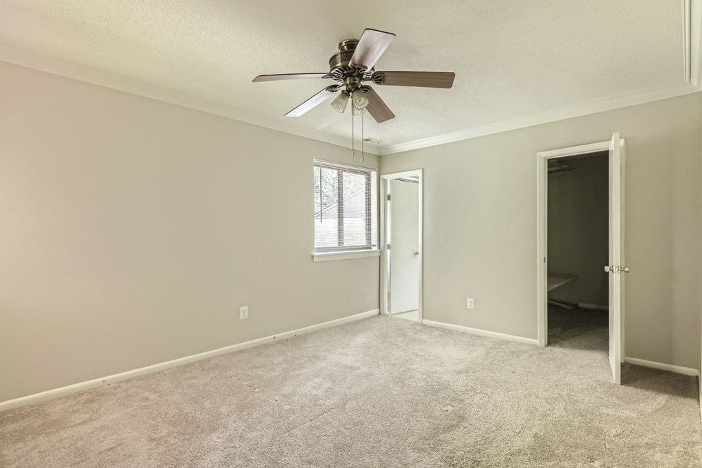 an empty living room with a ceiling fan