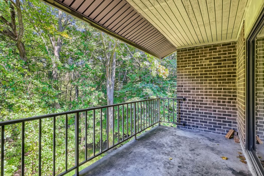 a balcony with a brick building and some trees