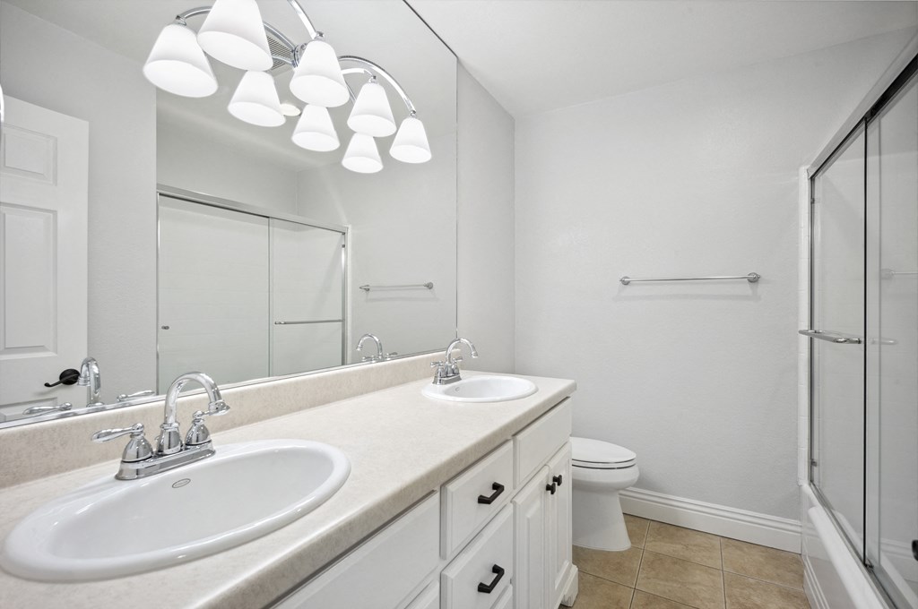a bathroom with two sinks and a shower and a toilet