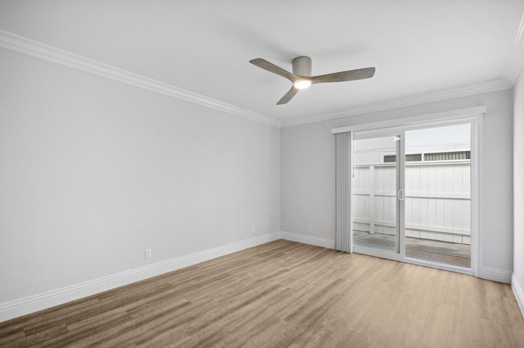 an empty living room with white walls and a ceiling fan