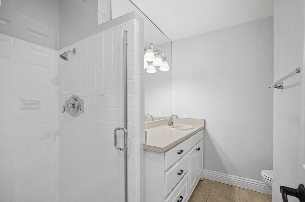 a white bathroom with a shower and a sink