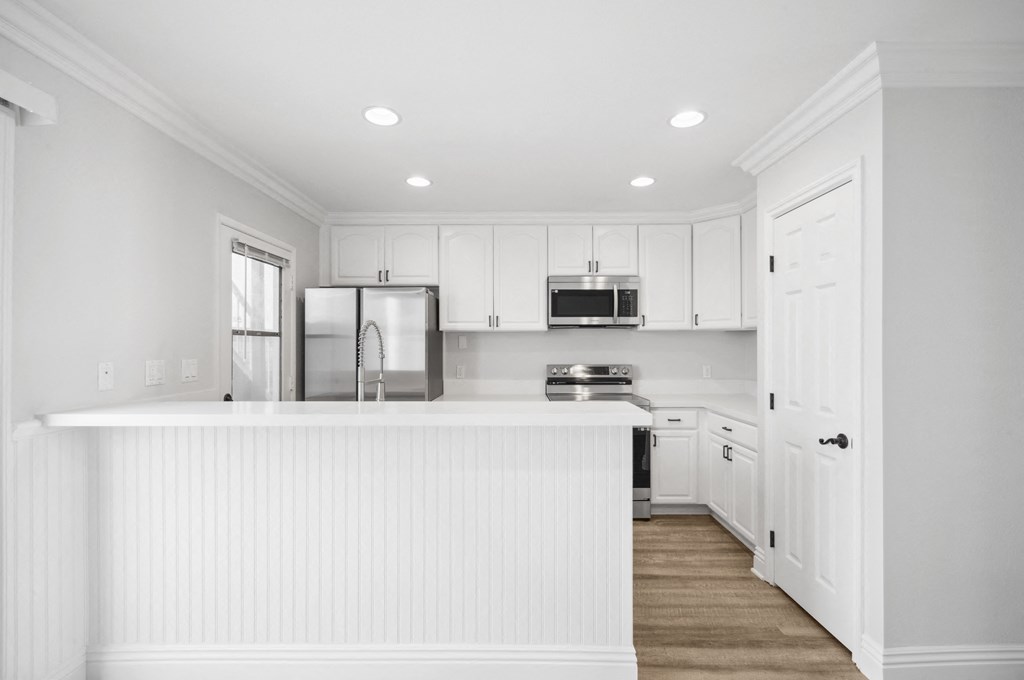 a white kitchen with white cabinets and a white counter top