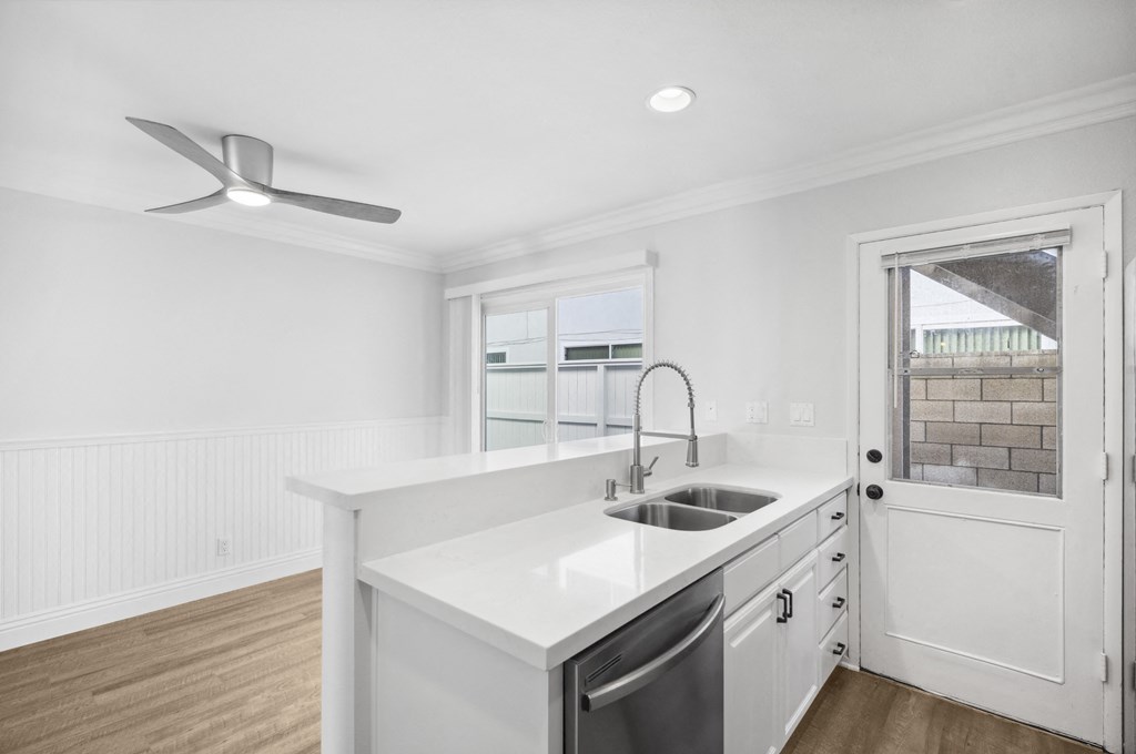 a white kitchen with a sink and a window