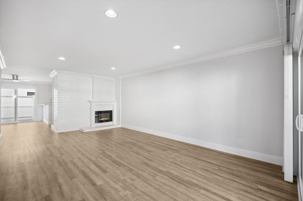 an empty living room with white walls and a fireplace