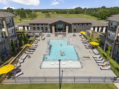 A large swimming pool surrounded by lounge chairs and umbrellas.