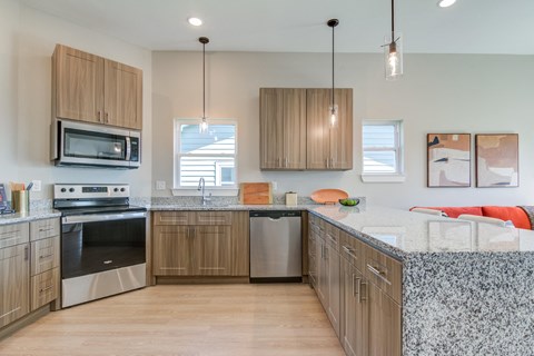 A kitchen with wooden cabinets and a granite countertop.