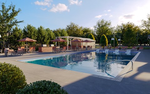 A large outdoor swimming pool surrounded by trees and a pavilion.