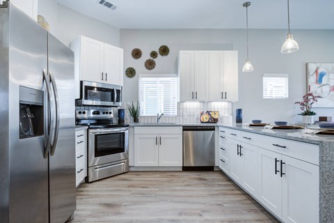 A modern kitchen with white cabinets and stainless steel appliances.