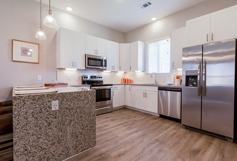 A kitchen with a refrigerator on the right side.