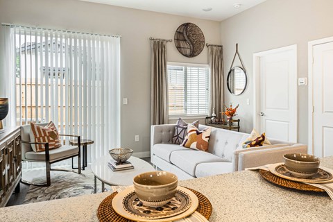 A living room with a white couch and a coffee table with a bowl on it.