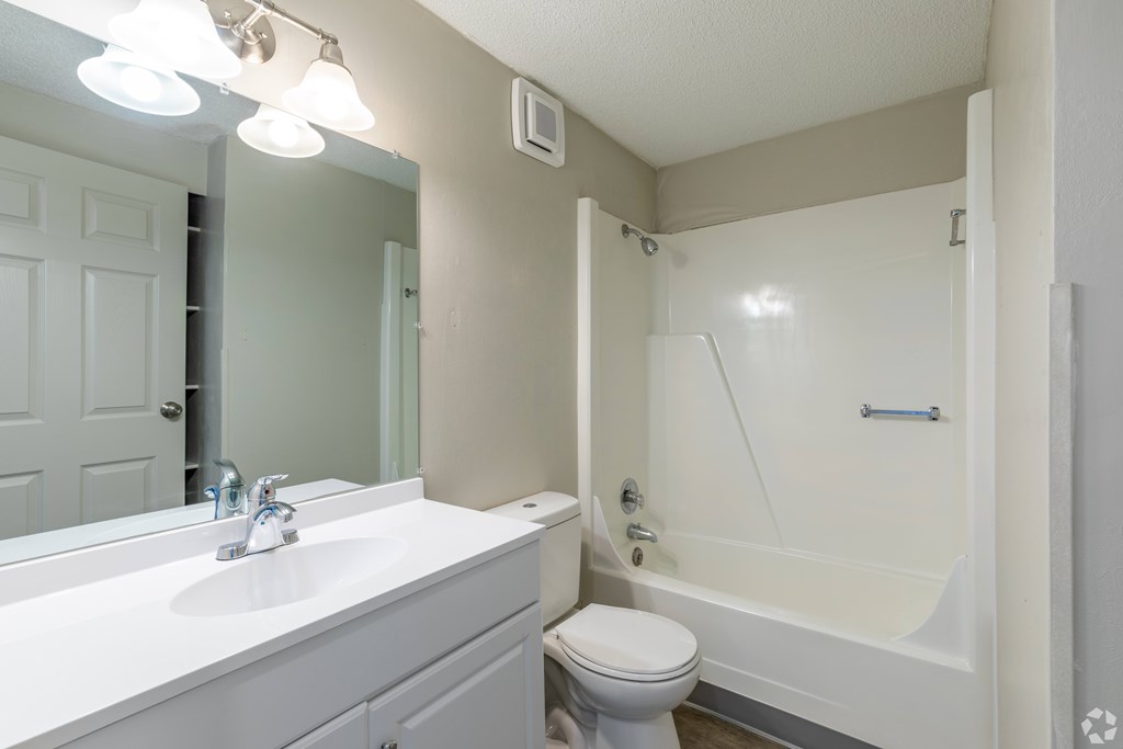 A white bathroom with a toilet, sink, and bathtub.