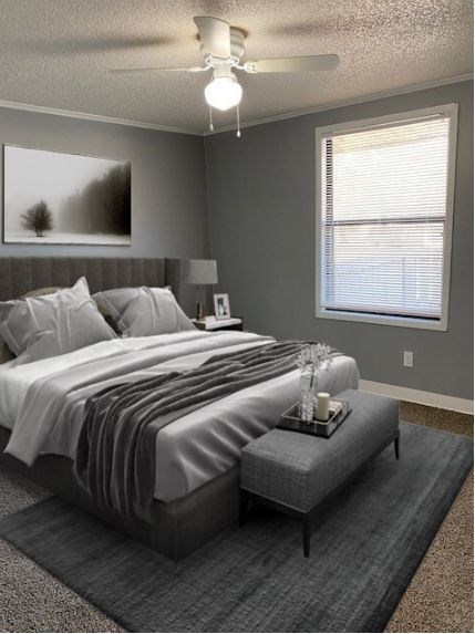 A bedroom with a bed, nightstand, and window.