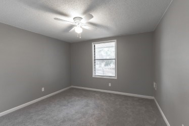 A room with a ceiling fan and a window.