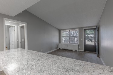A spacious room with a marble floor and a window with blinds.
