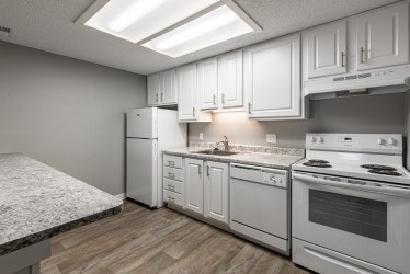A kitchen with white appliances and cabinets.