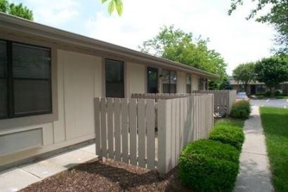 A white picket fence in front of a building.