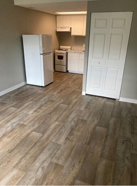 A kitchen with a white fridge and a white door.