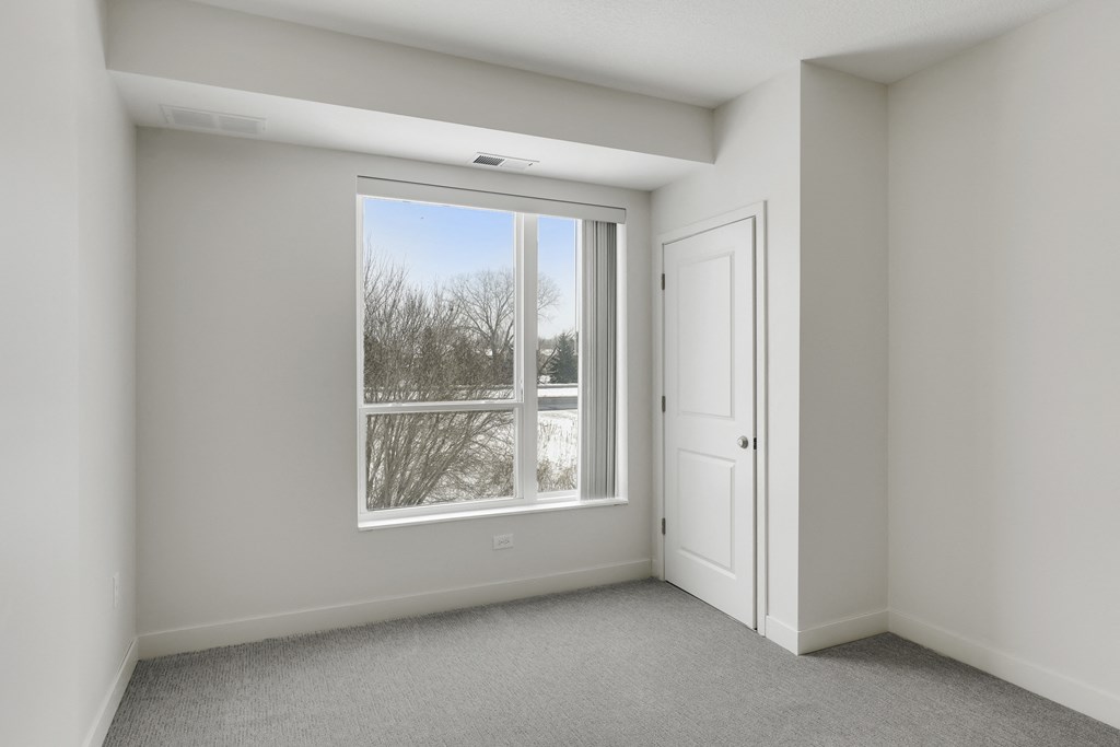 an empty room with a window and a door