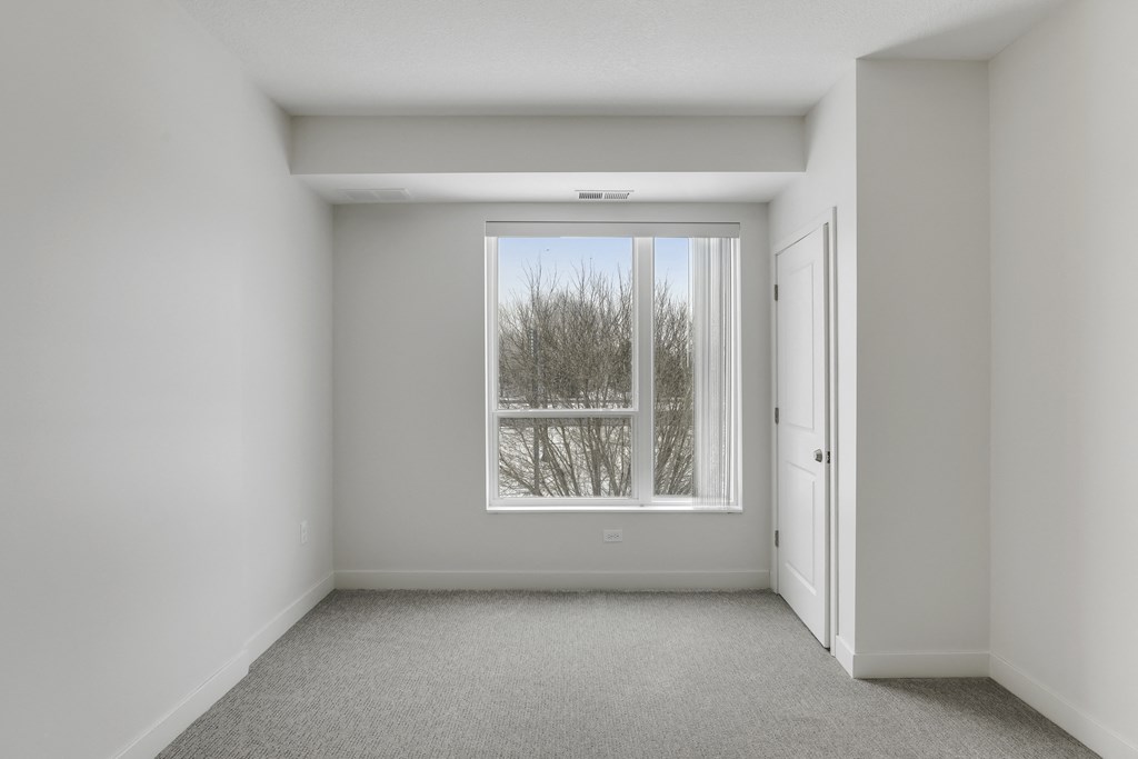 an empty room with a window and a door