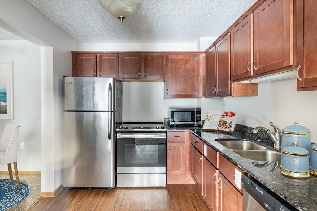 a kitchen with wood cabinets and stainless steel appliances