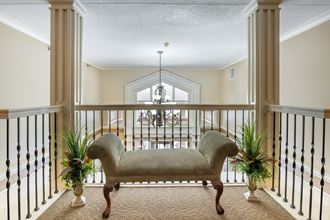 a large balcony with a couch and two potted plants