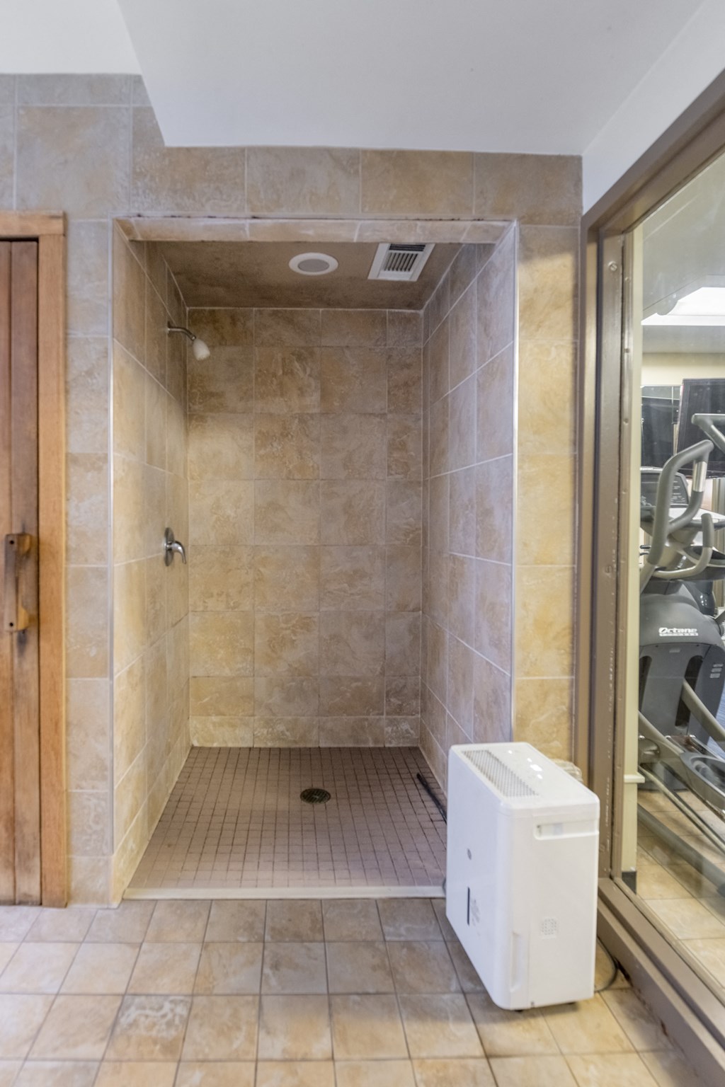 a large walk in shower with a water heater on the floor