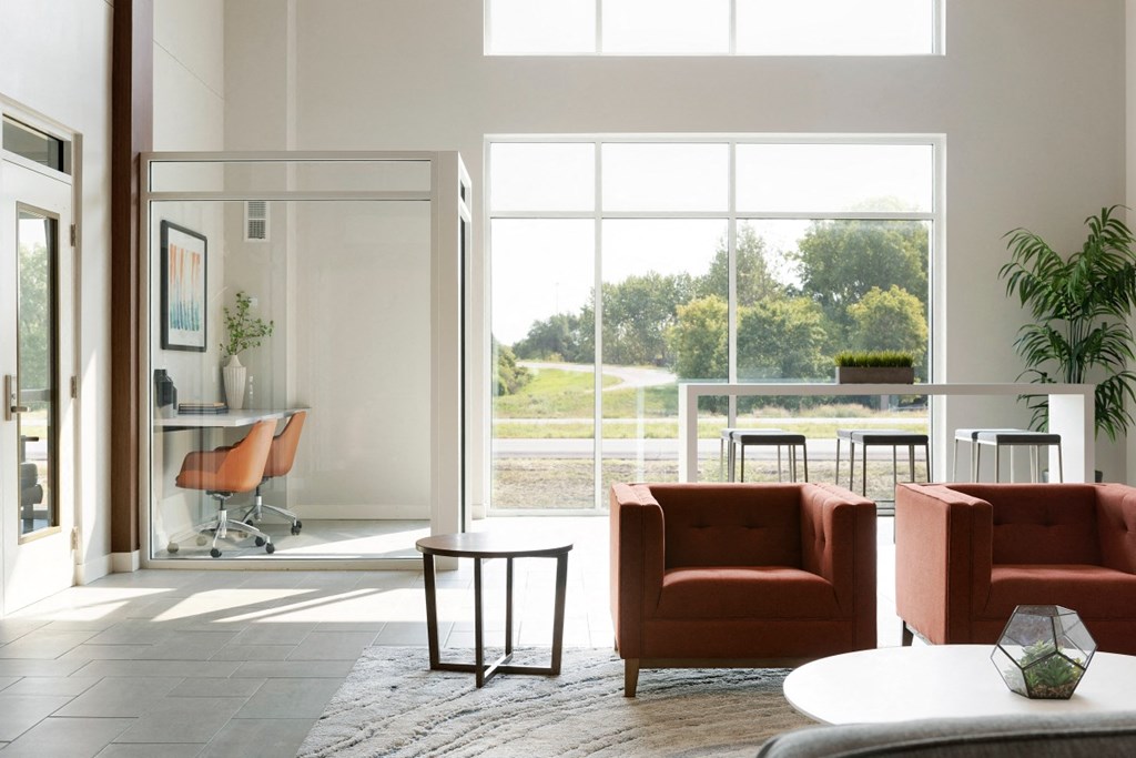a living room with orange chairs and a white table