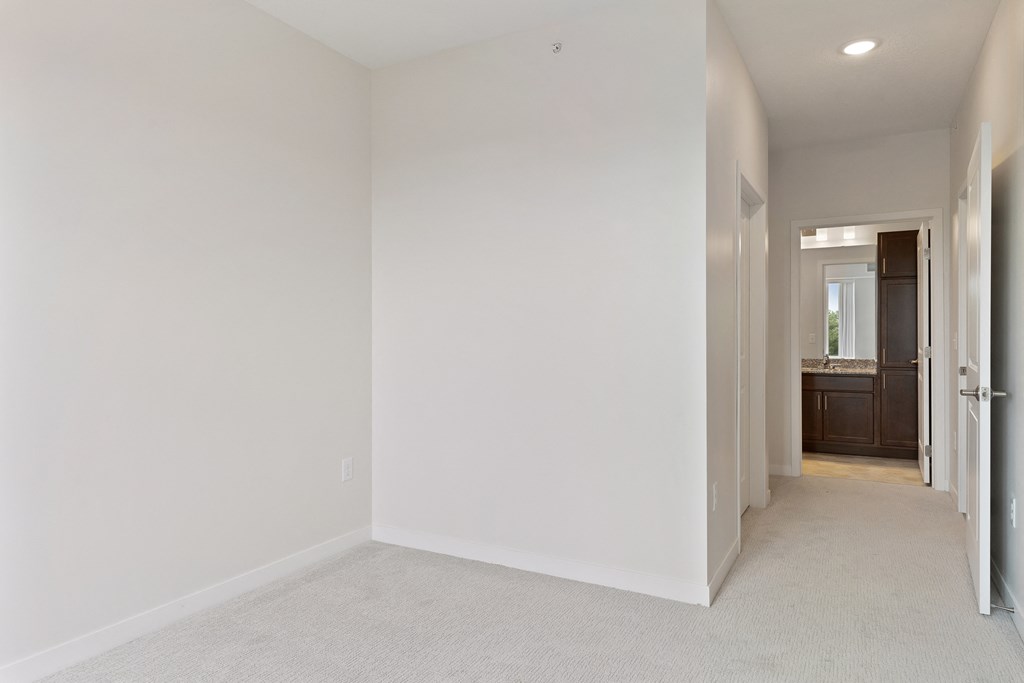 A white room with a carpeted floor and a doorway leading to another room at Sonder Point 50+ Apartments, Minnesota