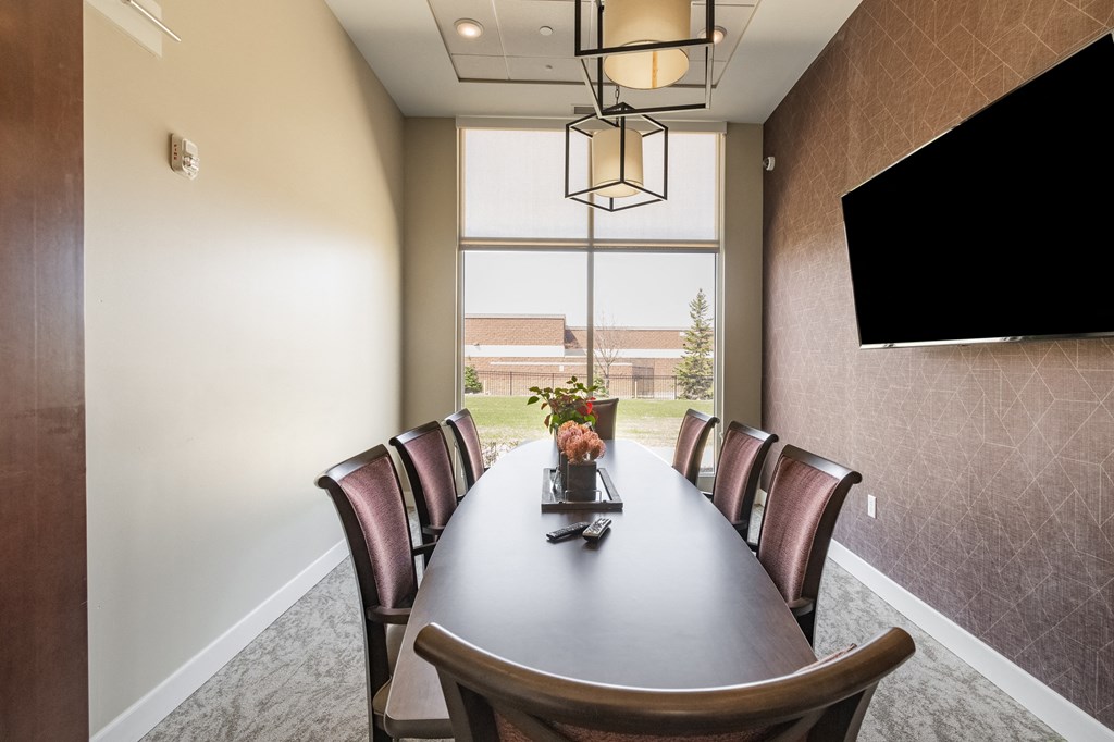 a conference room with a large window and a table with chairs