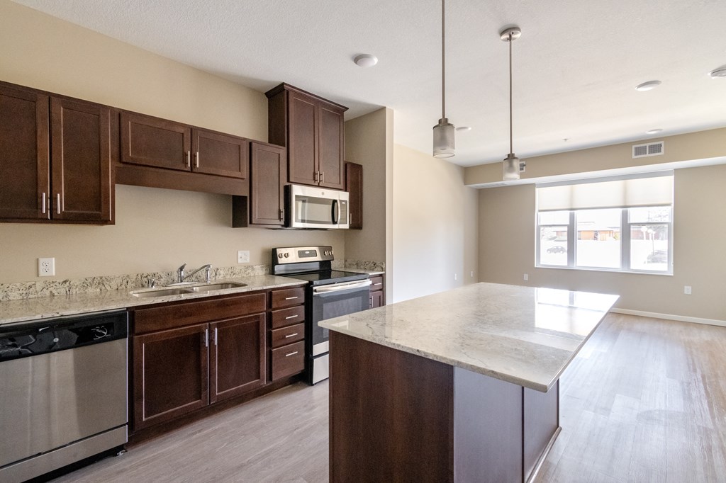 a kitchen with dark wood cabinets and a white counter top