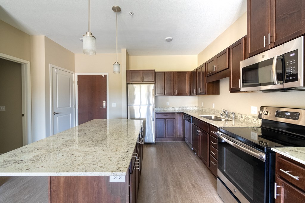 a kitchen with a large island with granite countertops