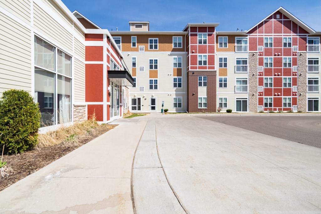 a view of the exterior of a multifamily building on a sunny day