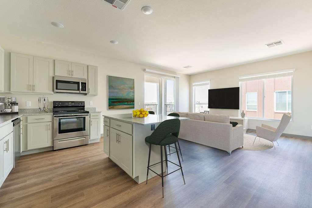 a kitchen and living room with hardwood floors and white cabinets at Copa Flats, Maricopa, 85138