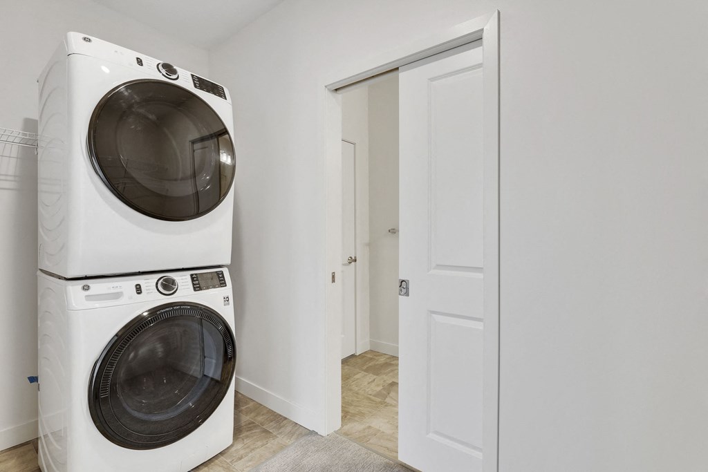 a white washer and dryer in a room with a door